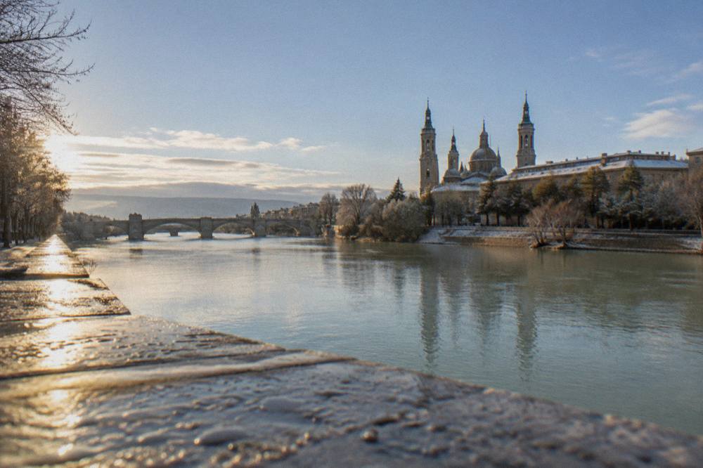 Frost-covered rooftops of Zaragoza's old town seen at sunrise with the Ebro valley beyond