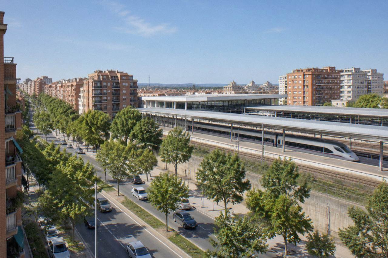 A high-speed train standing at a platform under a modern station roof
