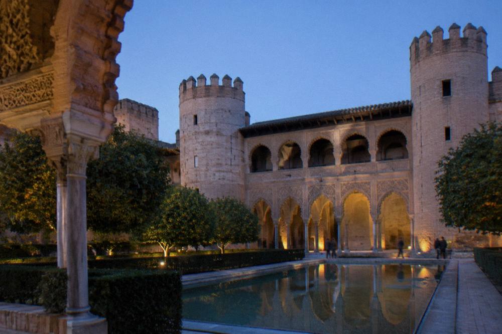The ornate brick arches and carved stucco of the Aljafería palace courtyard in Zaragoza