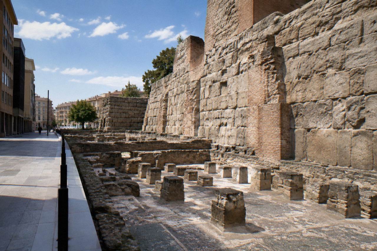 Stone columns and excavated Roman wall fragments displayed in an underground museum gallery in Zaragoza