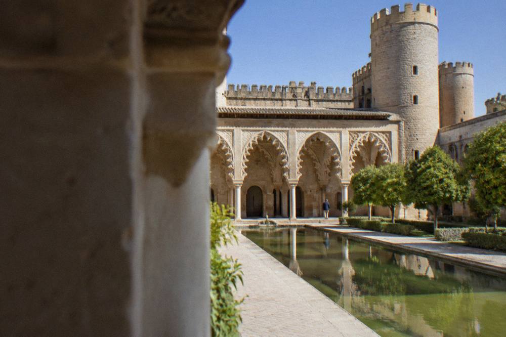 The Islamic arches of the Aljafería palace courtyard in afternoon light