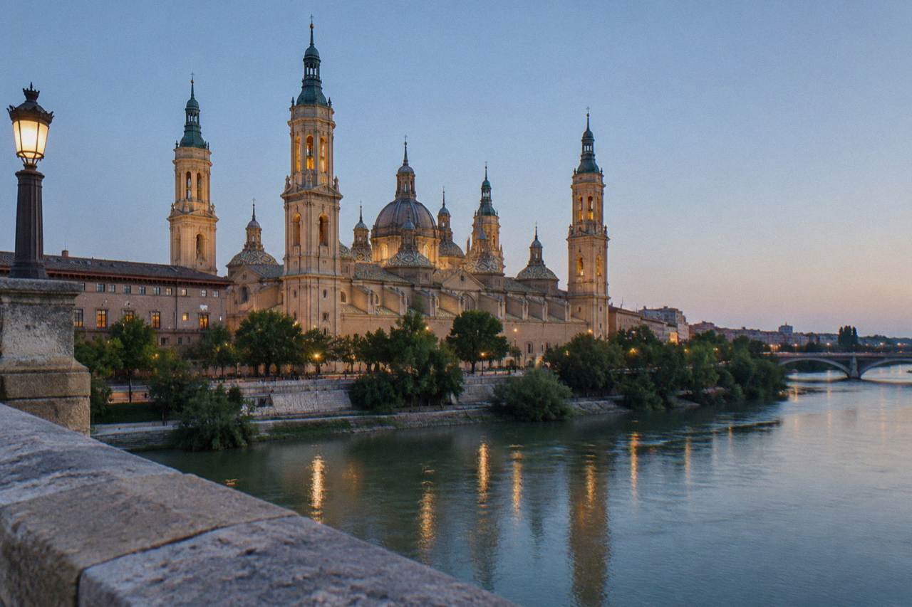 The Basilica del Pilar and the Ebro river seen at dusk from the stone bridge in Zaragoza