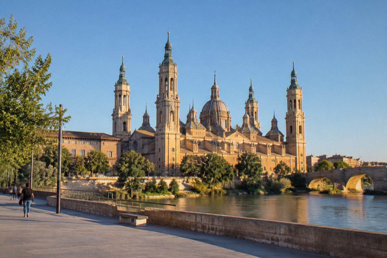 The Basilica del Pilar and its towers rising above the Ebro river in Zaragoza at golden hour