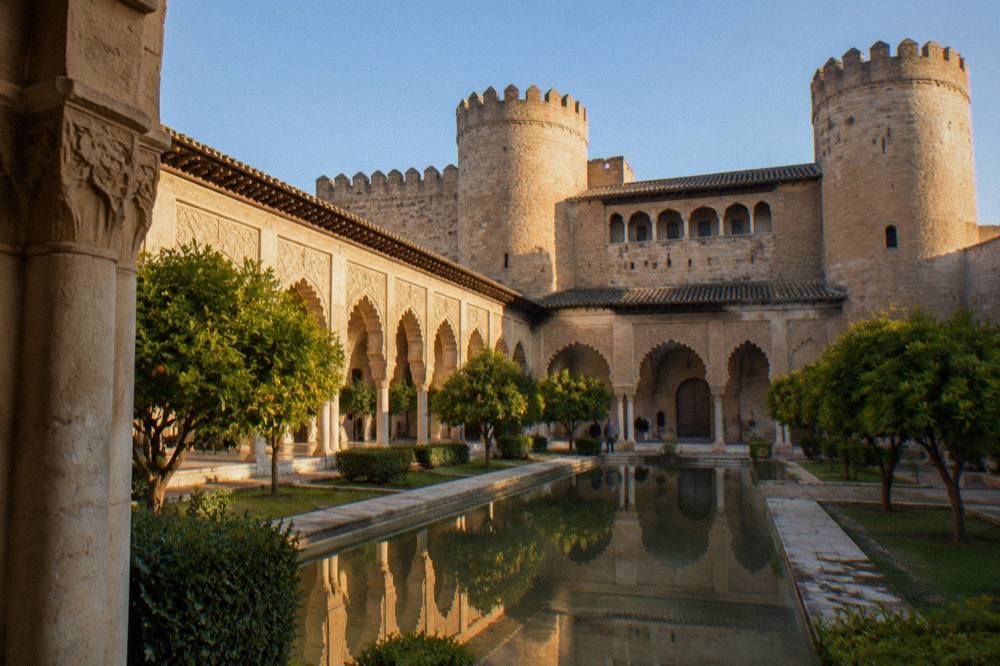 The Aljafería palace courtyard in Zaragoza with its Islamic arches and reflecting pool