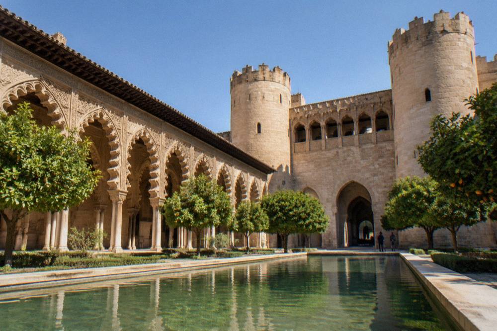 The Aljafería palace courtyard in Zaragoza with its ornate Moorish arches in morning light