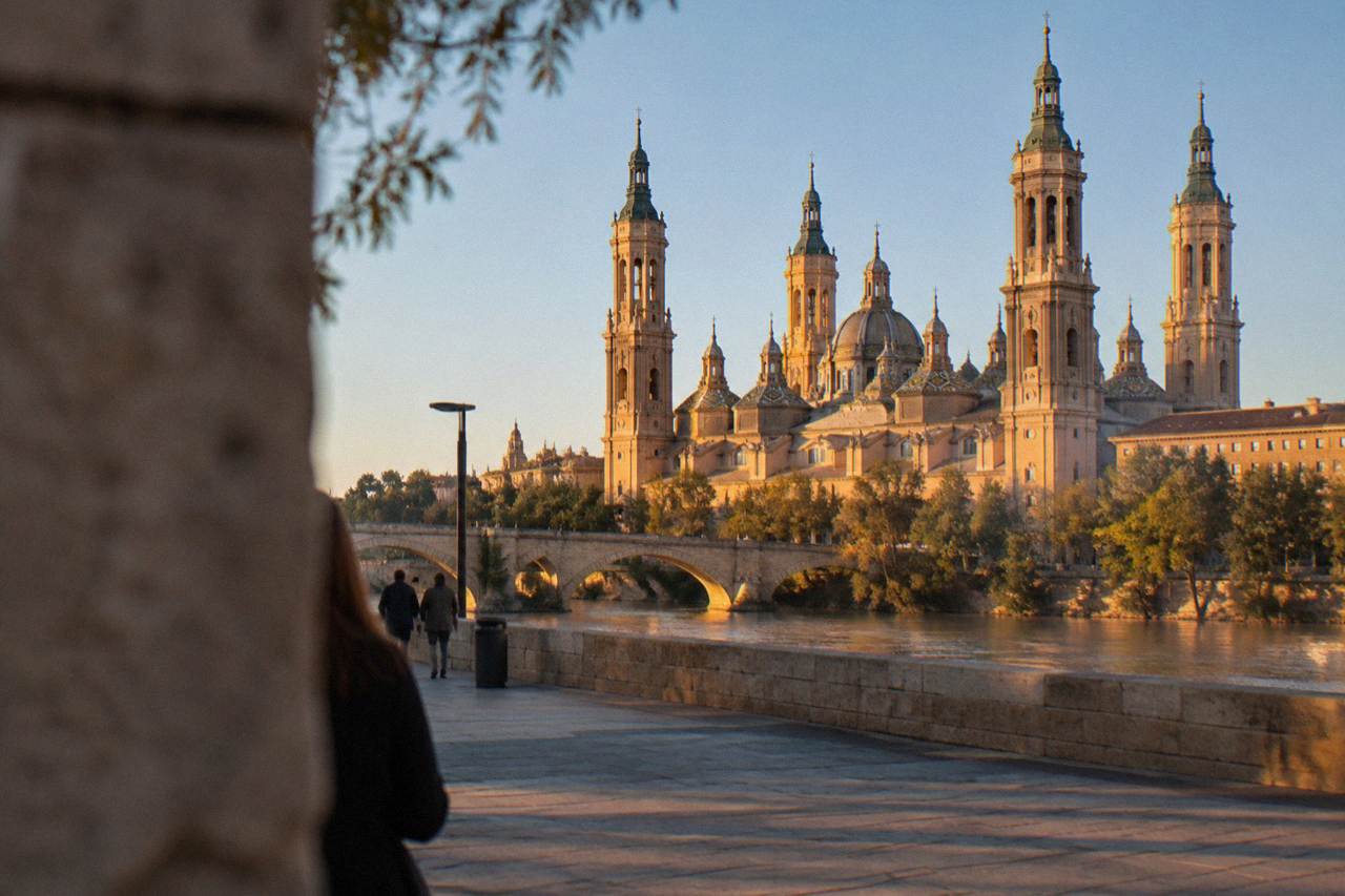 The Baroque towers of the Basílica del Pilar rising above the Ebro river in Zaragoza at golden hour