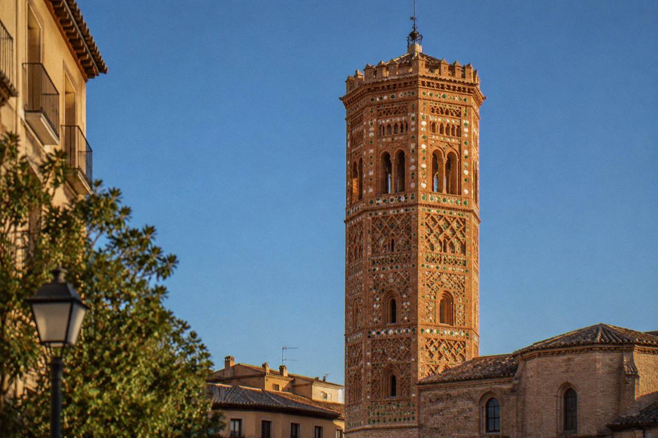 The brick tower of the Mudejar church of La Magdalena in Zaragoza rising over a quiet square