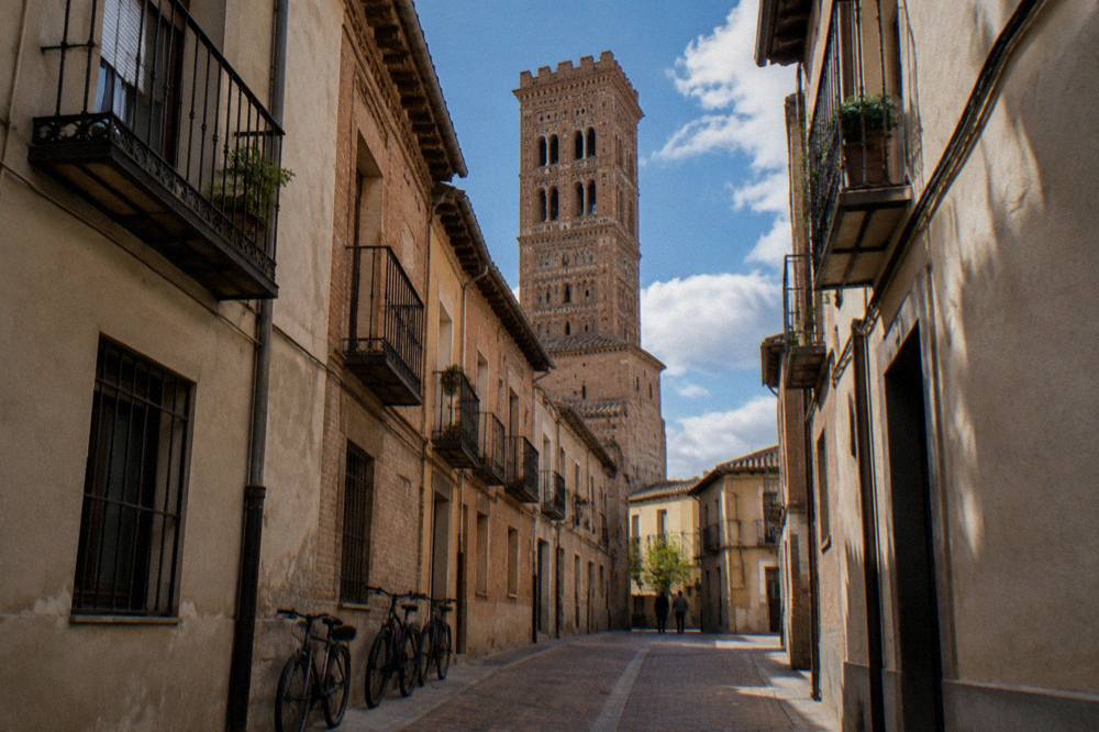 A narrow brick street in the La Magdalena barrio of Zaragoza with balconies and parked bicycles