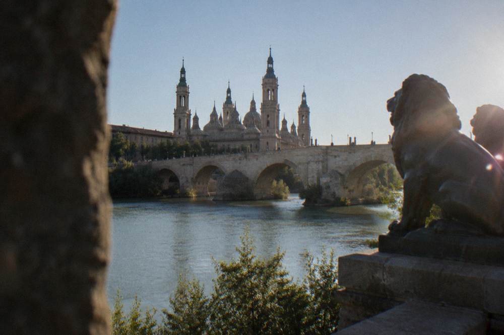 The stone arches of the Puente de Piedra over the Ebro river in Zaragoza seen from the bank