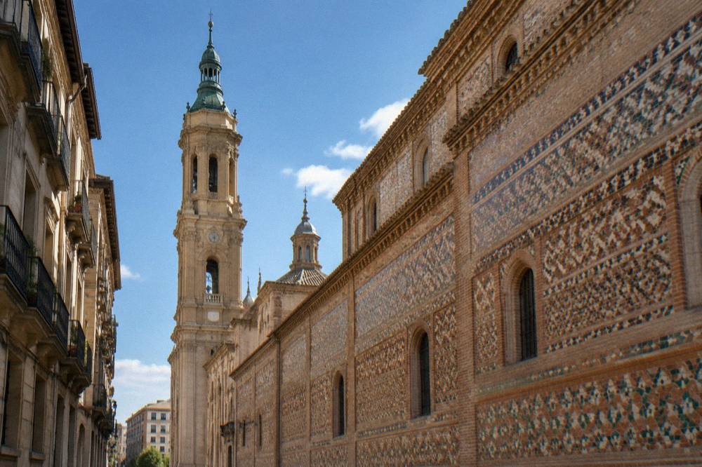 The ornate Mudéjar brick facade of La Seo cathedral in Zaragoza seen from a narrow old street