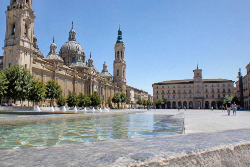 Visitors looking out from a high viewpoint over the domes and rooftops of Zaragoza