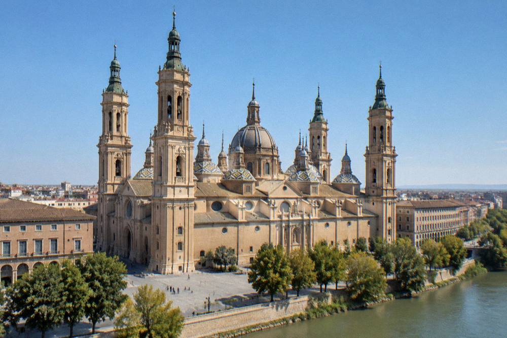 A historic tiled-domed basilica tower in Zaragoza under a wide sky
