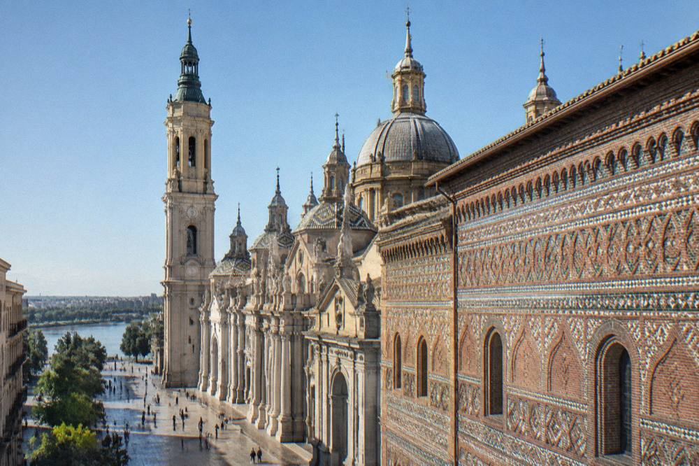 The baroque facade and dome of La Seo cathedral seen from Plaza del Pilar beside the basilica