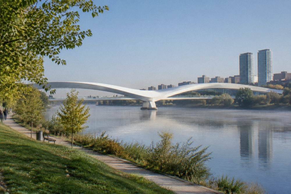 A wide green park beside a river with modern towers visible in the distance