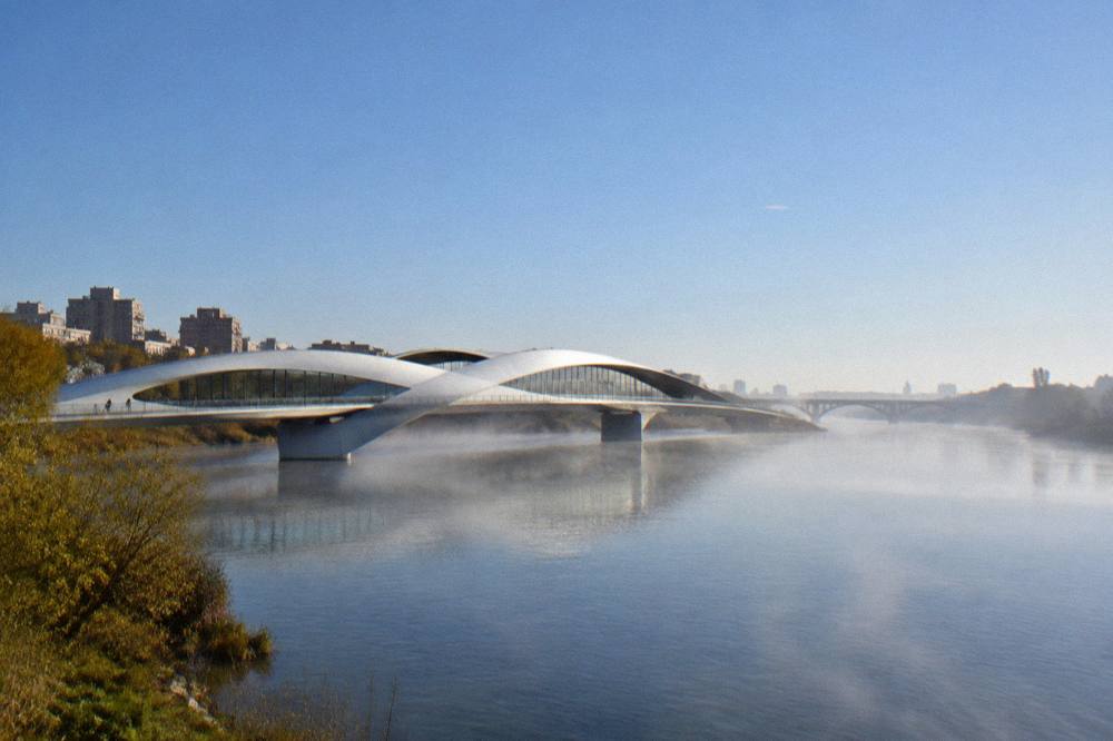 A wide river at sunrise with mist over the water and a modern bridge silhouette in the distance