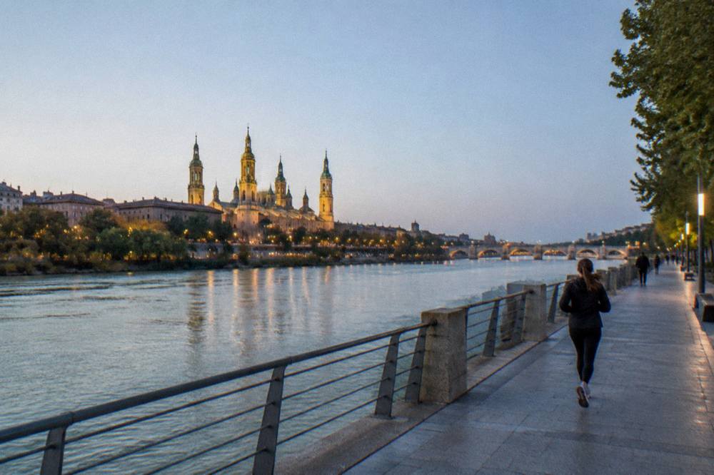 Evening view across the Ebro towards the illuminated towers of the old city from the Expo riverbank
