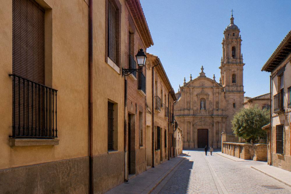 A small stone village street in rural Aragon under a wide sky
