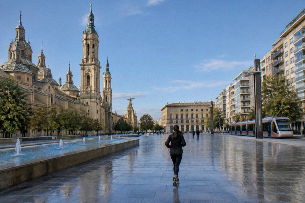 A tram passing modern apartment buildings on a wide Zaragoza avenue