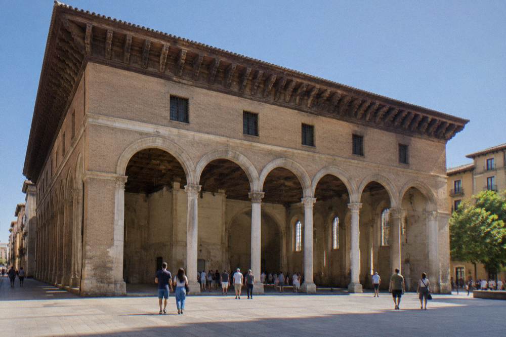 The high stone interior hall of La Lonja with visitors at an exhibition