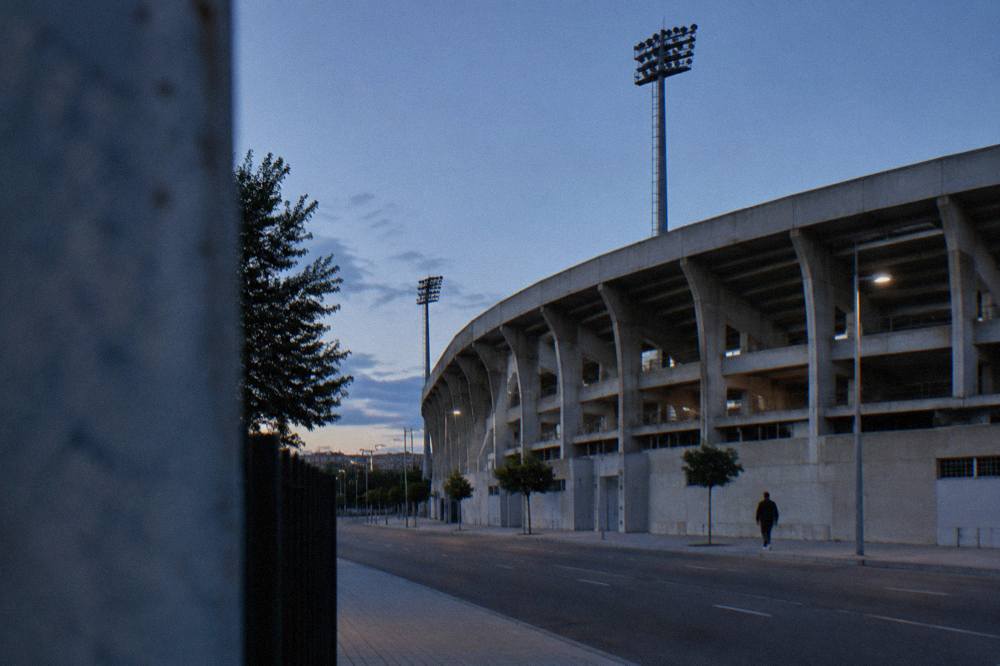 The exterior wall of a football stadium with club colours painted on the concrete