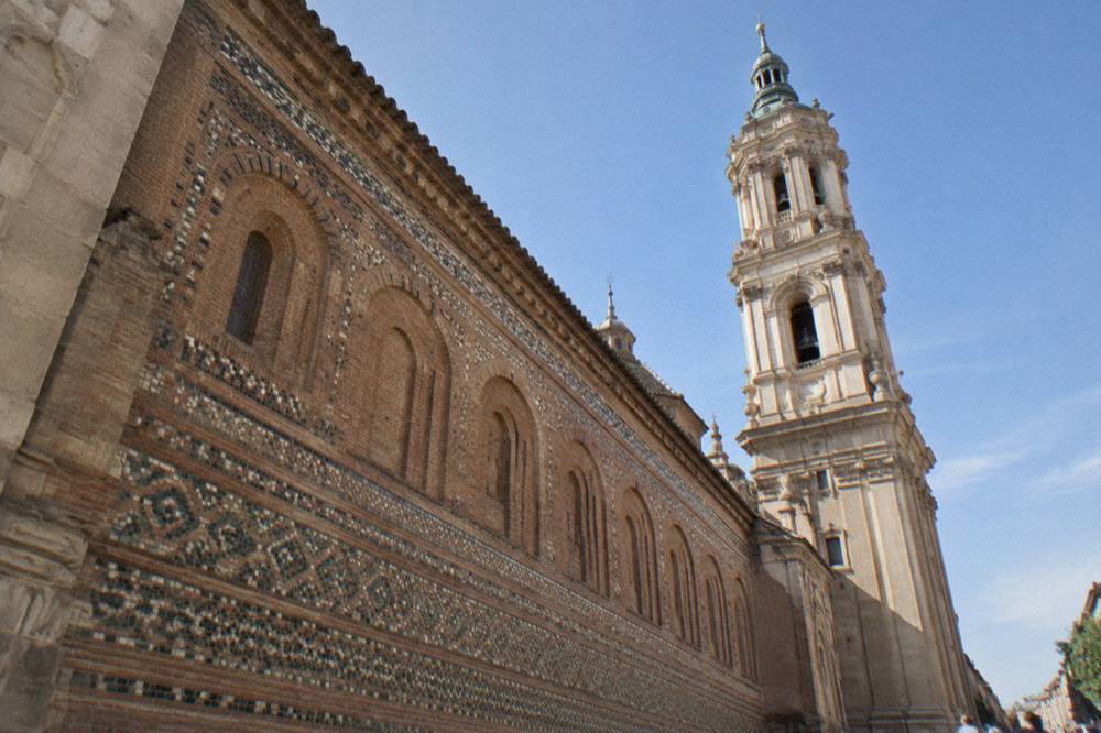 The Mudejar brick wall and blind arches of La Seo Cathedral seen from the street