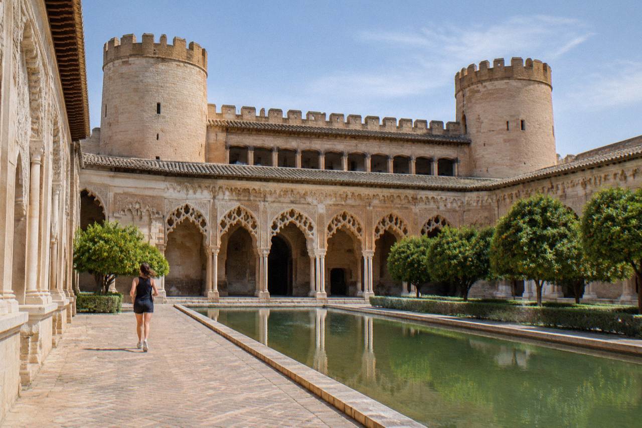 The ornate brick arches and carved plasterwork of the Aljafería Palace courtyard in Zaragoza