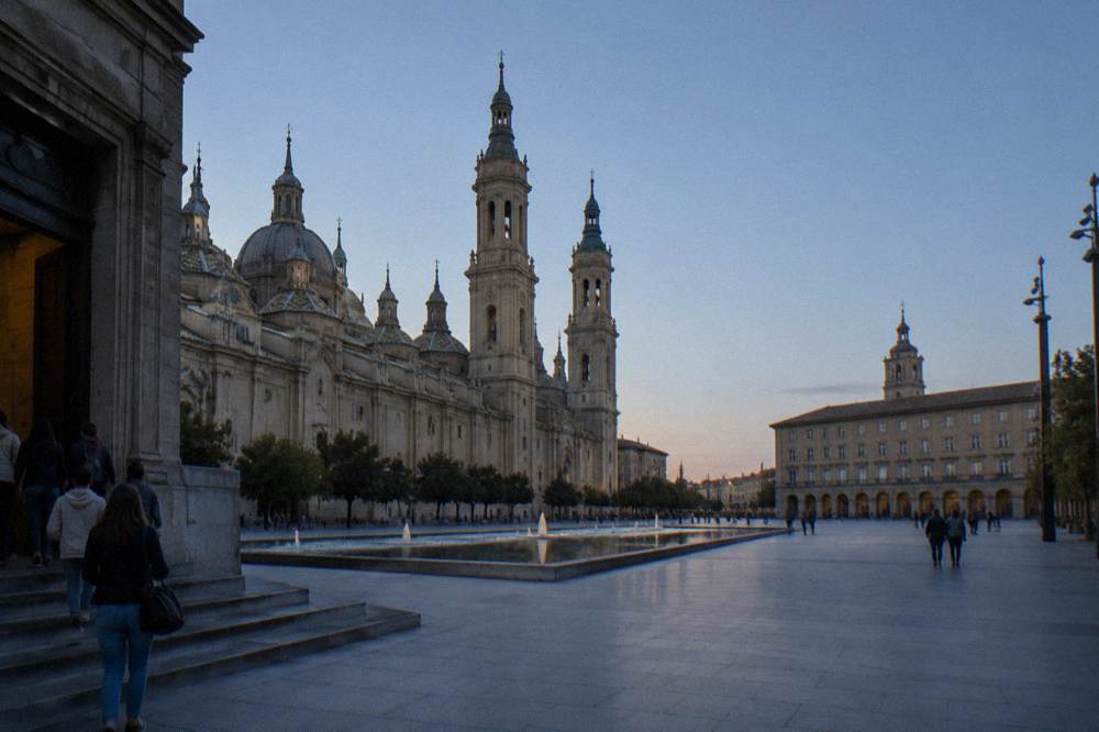 A stone museum entrance on a Zaragoza street with visitors at the doorway