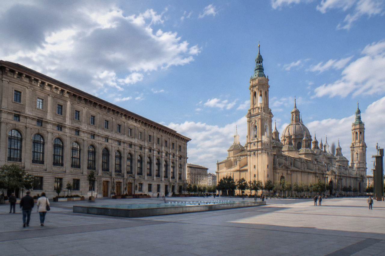 The closed facade of a grand early museum building on a wide square in Zaragoza