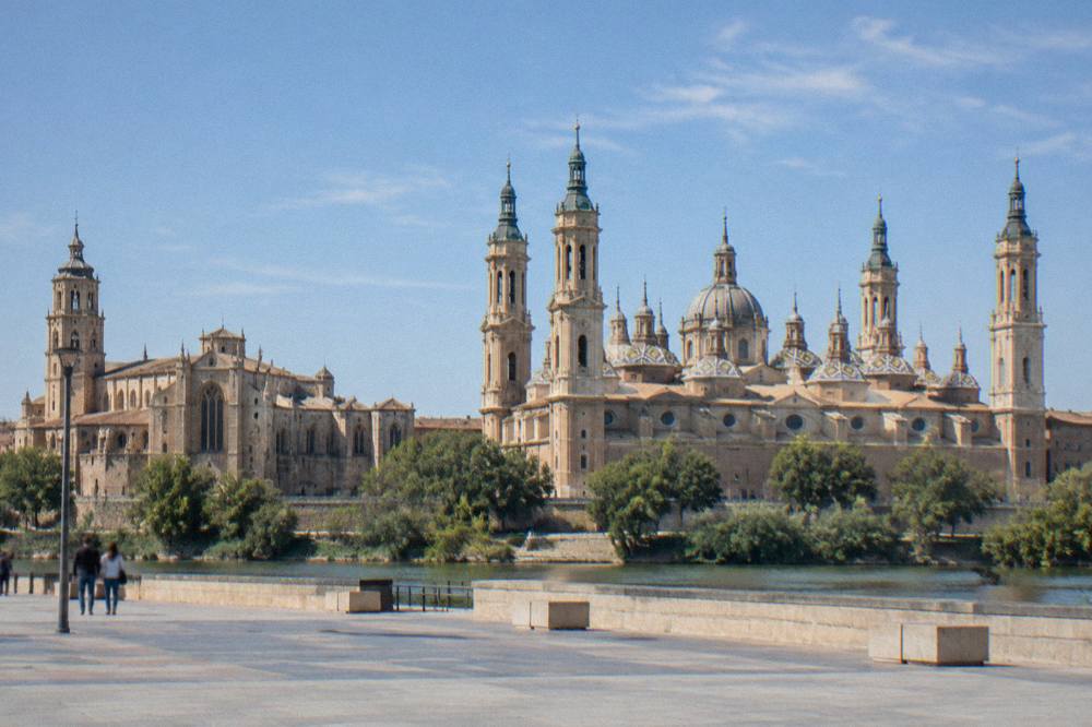 La Seo cathedral and the Basilica del Pilar seen side by side along the riverfront in Zaragoza