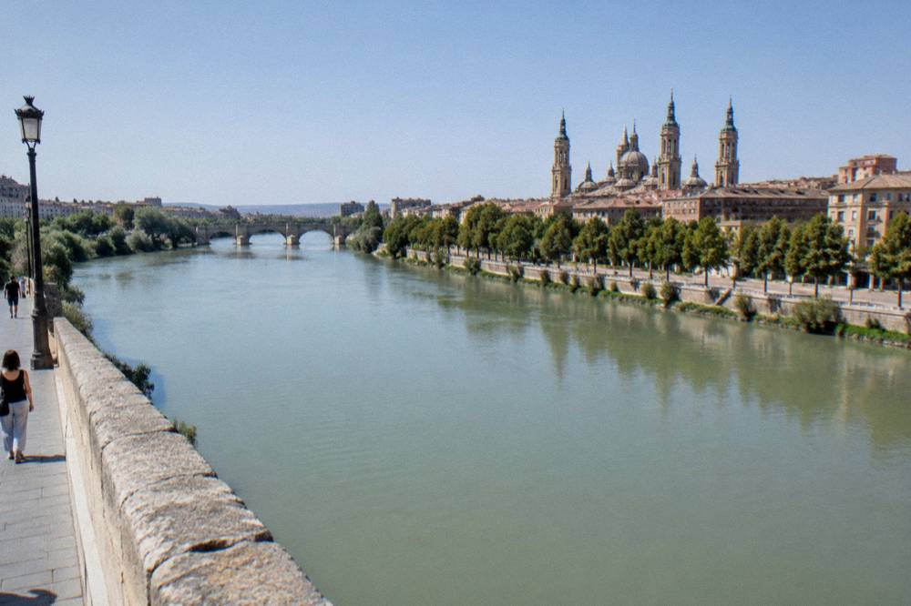 The Ebro river seen from the stone bridge with the old town roofline on the far bank
