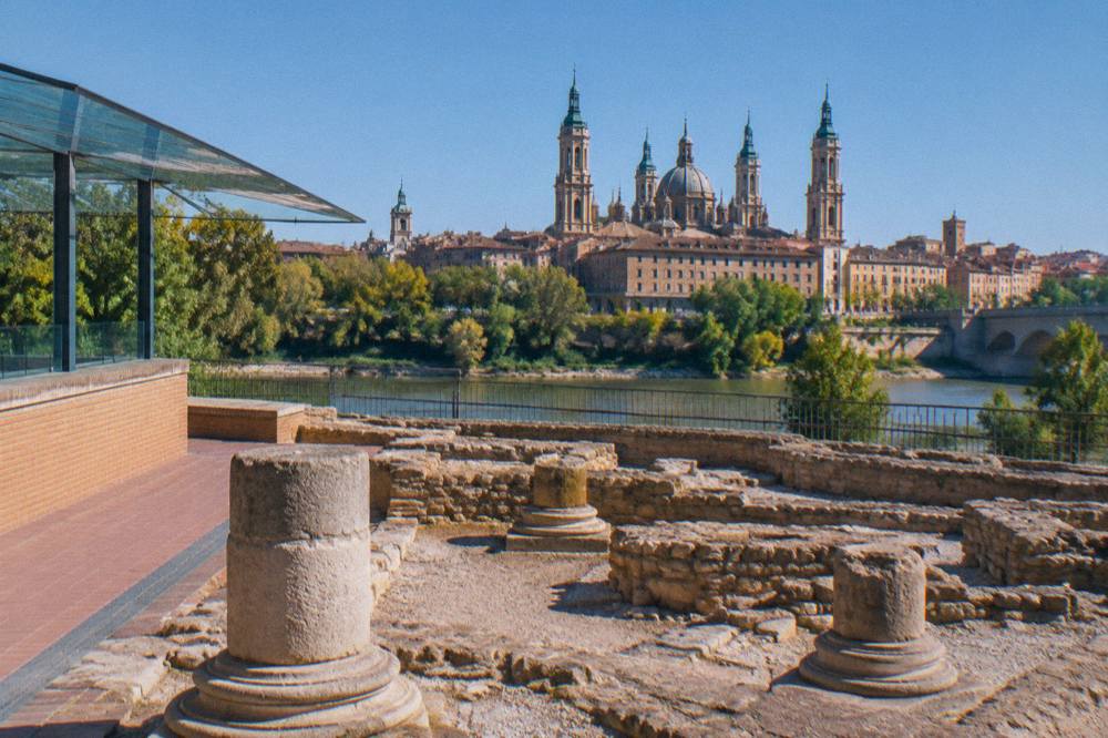 Baroque basilica dome rising above old-city rooftops seen from across the river