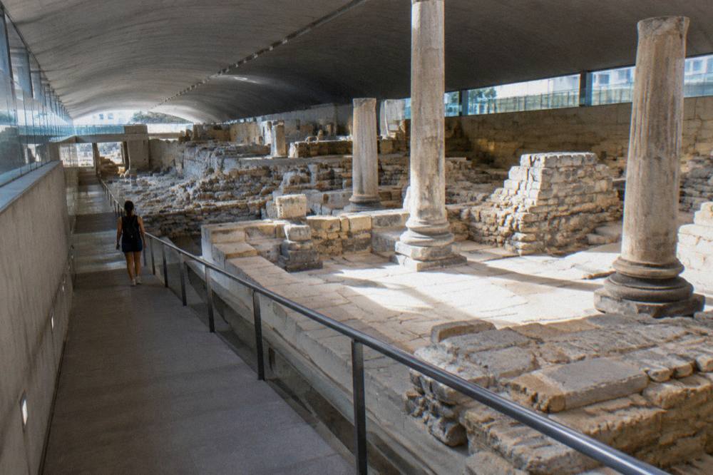 Walkway descending past stone Roman foundations inside the Forum museum in Zaragoza