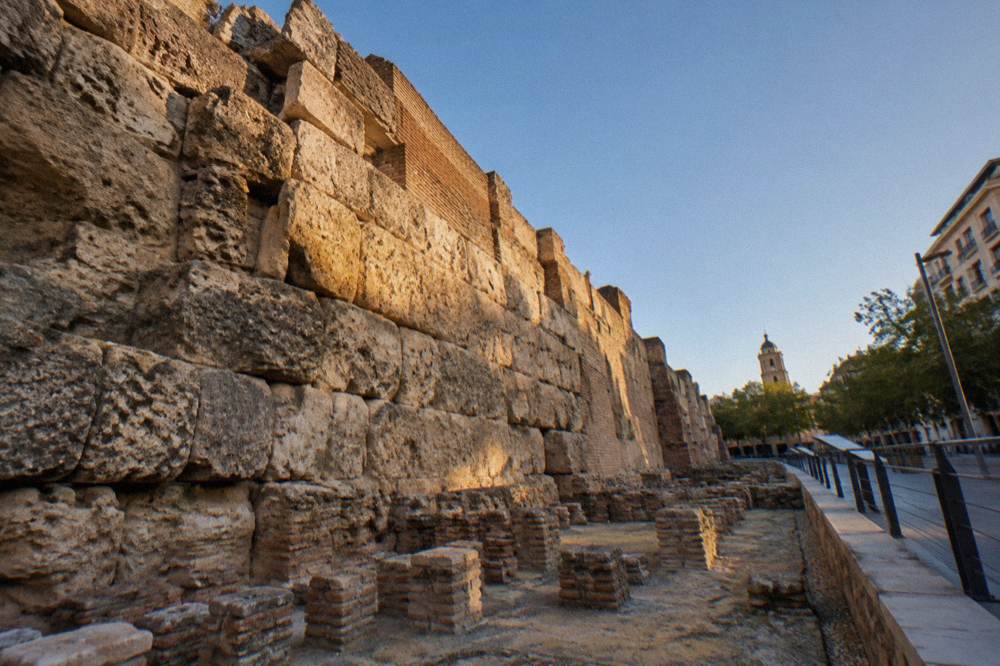 Excavated Roman wall of large stone blocks with walkway and interpretation panels