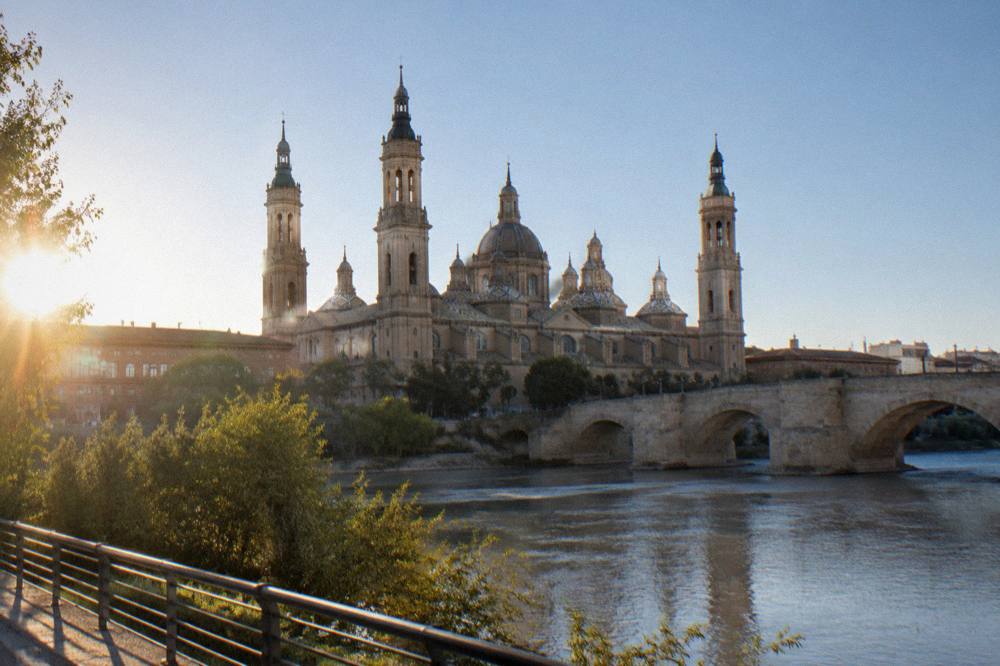 The stone bridge and basilica towers of Zaragoza seen from the Ebro riverbank near the old town