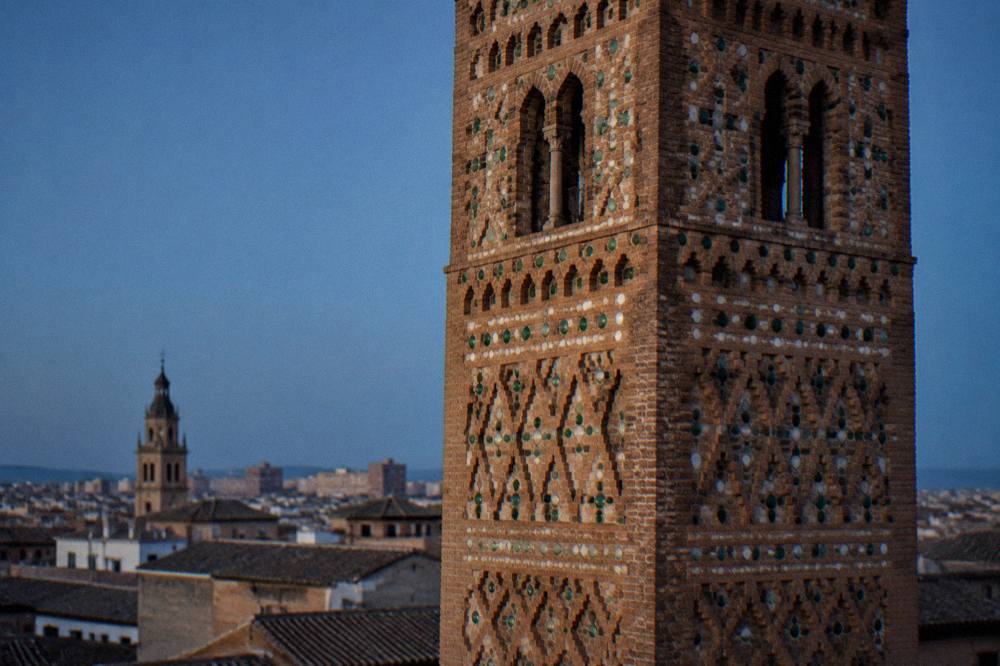 Close view of brick diamond and cross patterns on a Mudéjar tower facade in late afternoon light