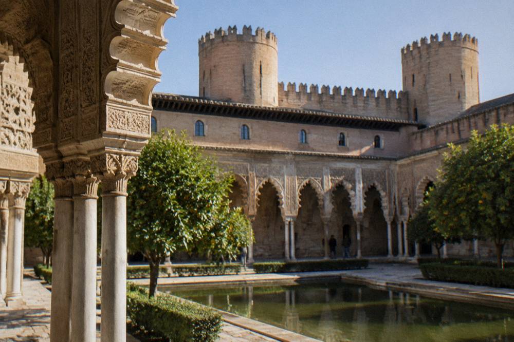 The Aljaferia palace courtyard in Zaragoza with Mudejar arches and ornate plasterwork