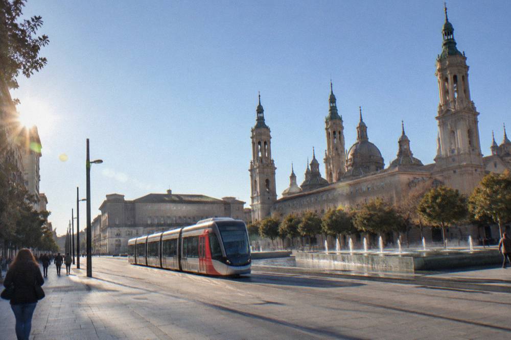 A Zaragoza tram passing modern and historic buildings on a city avenue in daylight