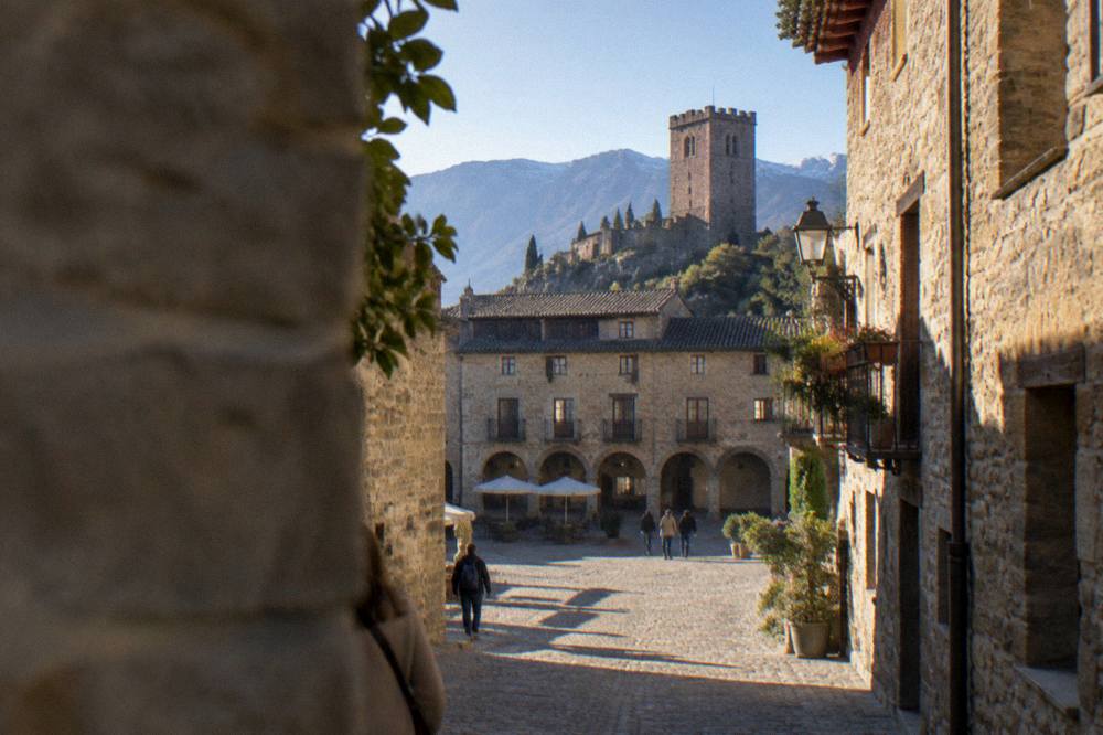 A narrow cobbled street in Ainsa old town lined by golden stone houses