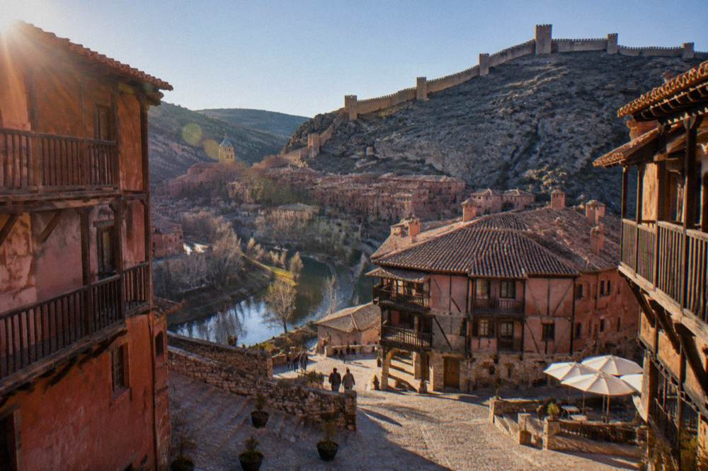 Sloping main square with timber-framed buildings and deep wooden eaves