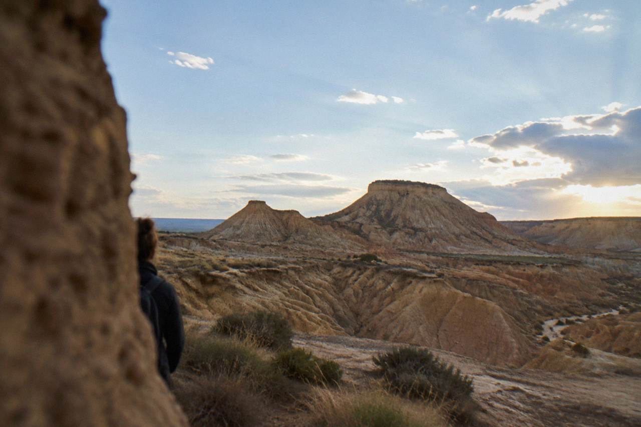 Wide view of eroded clay hills and dry ravines under a pale sky in a semi-desert landscape