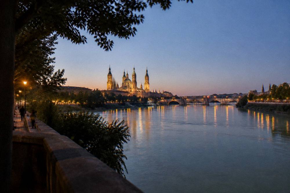 The lights of Zaragoza seen at dusk with the Ebro and the Basilica del Pilar in the distance