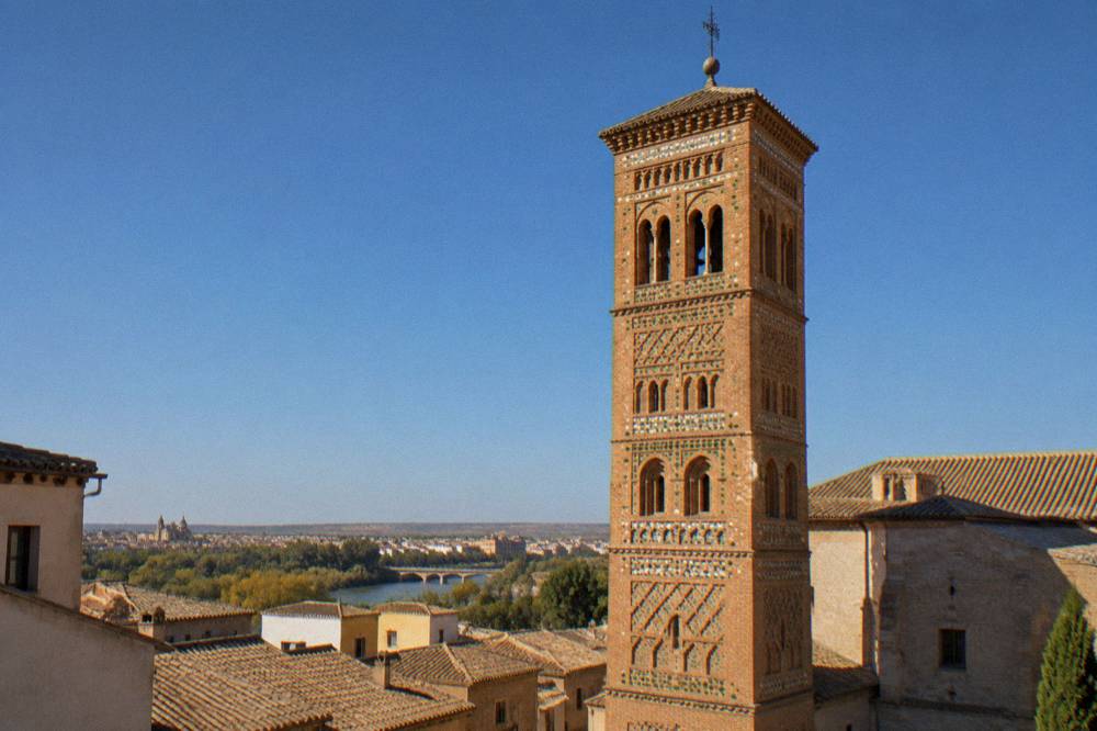 Golden late afternoon light on brick towers and rooftops in a Spanish hill town