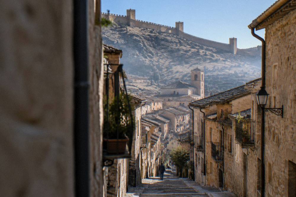 A narrow steep stone street lined with old houses in a Spanish hill town