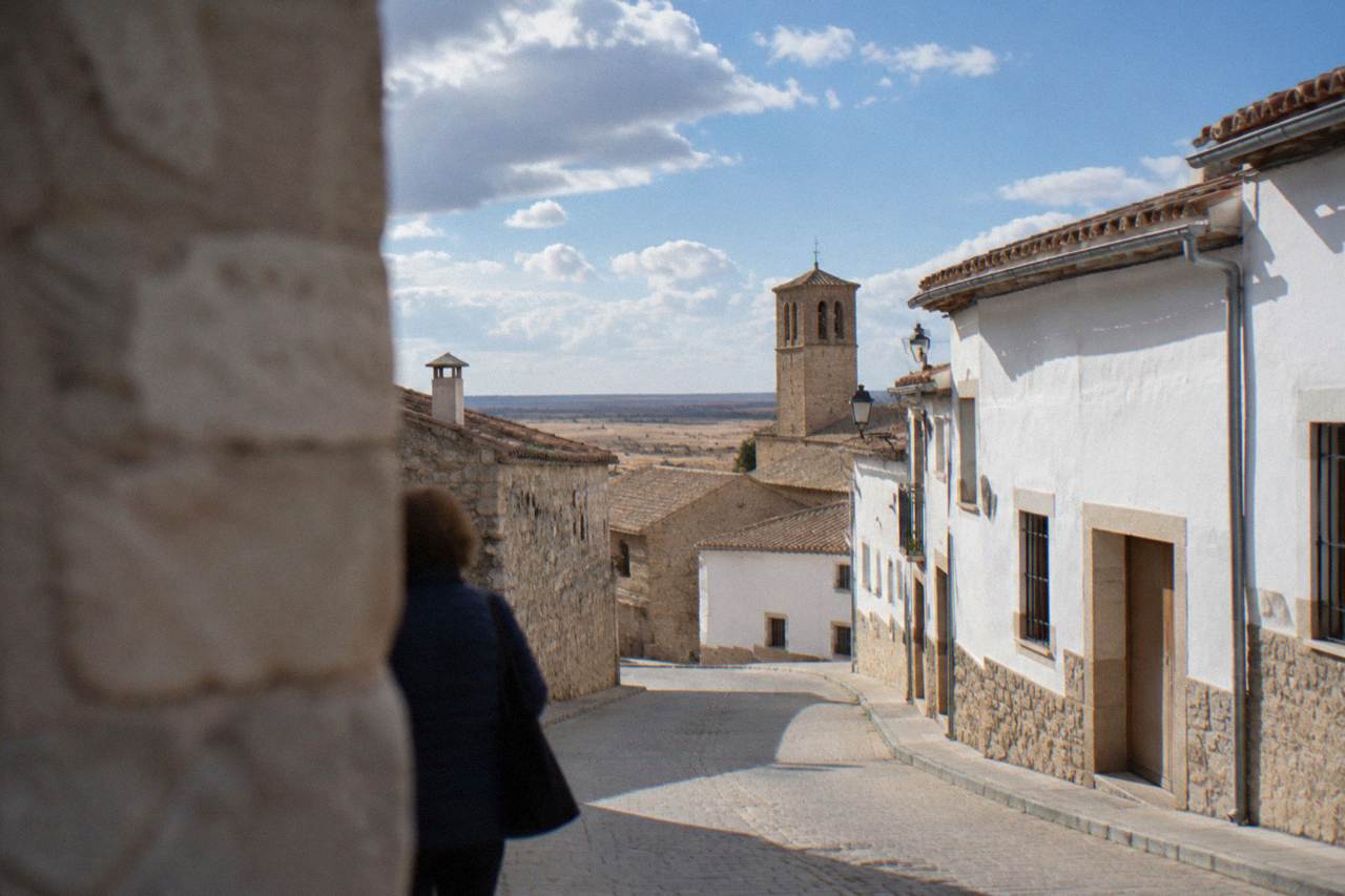 A small stone village street with whitewashed houses under a wide dry sky