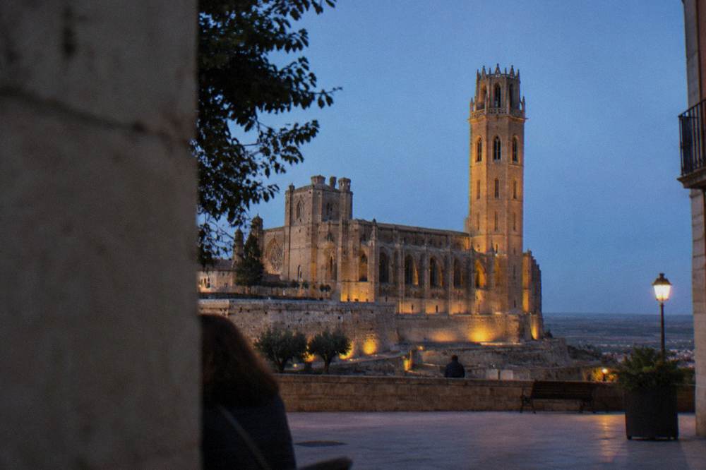 The bell tower of the Seu Vella seen from a plaza in Lleida in warm evening light