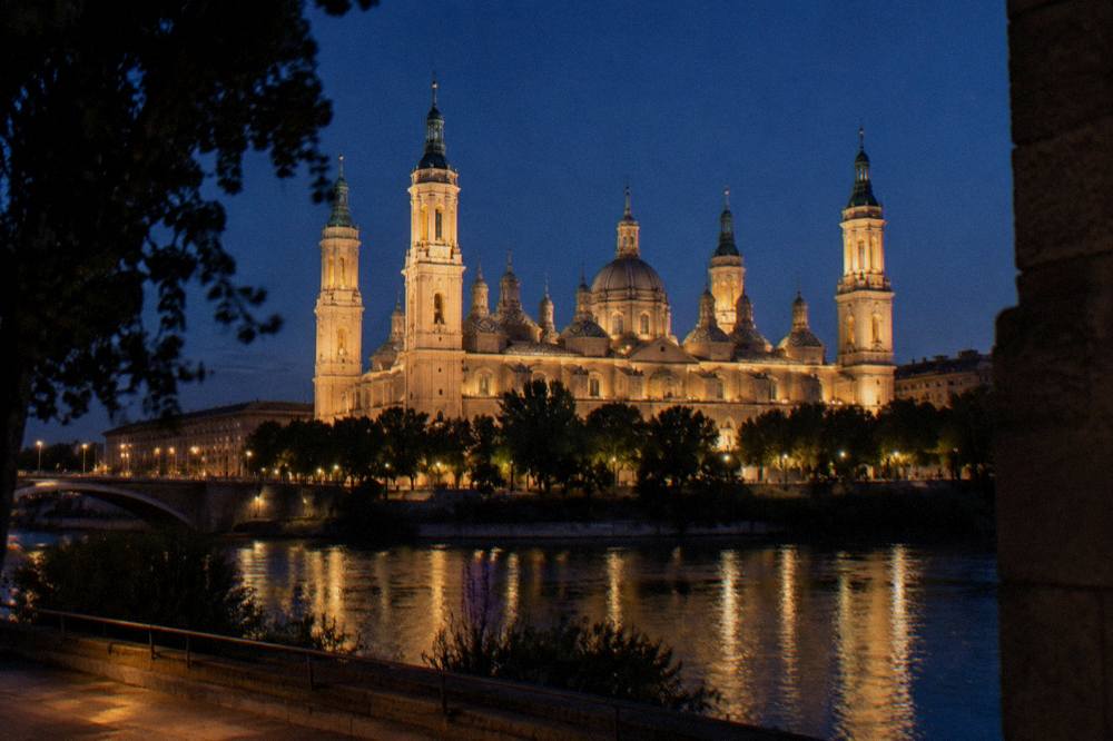 The illuminated nave of the Basilica del Pilar in Zaragoza seen from across the Ebro river at night