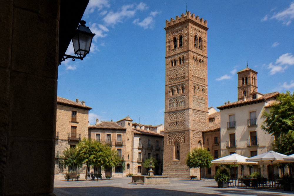 A stone square in Tarazona with Mudéjar brick towers rising above the rooftops
