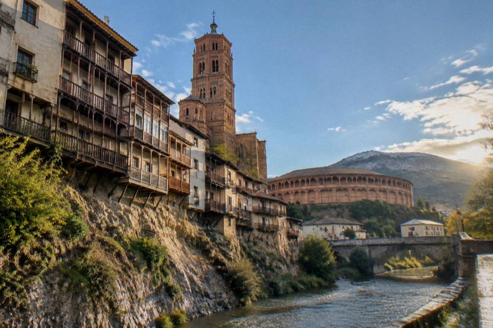 A small stone village with a church tower beneath the Moncayo mountain slopes