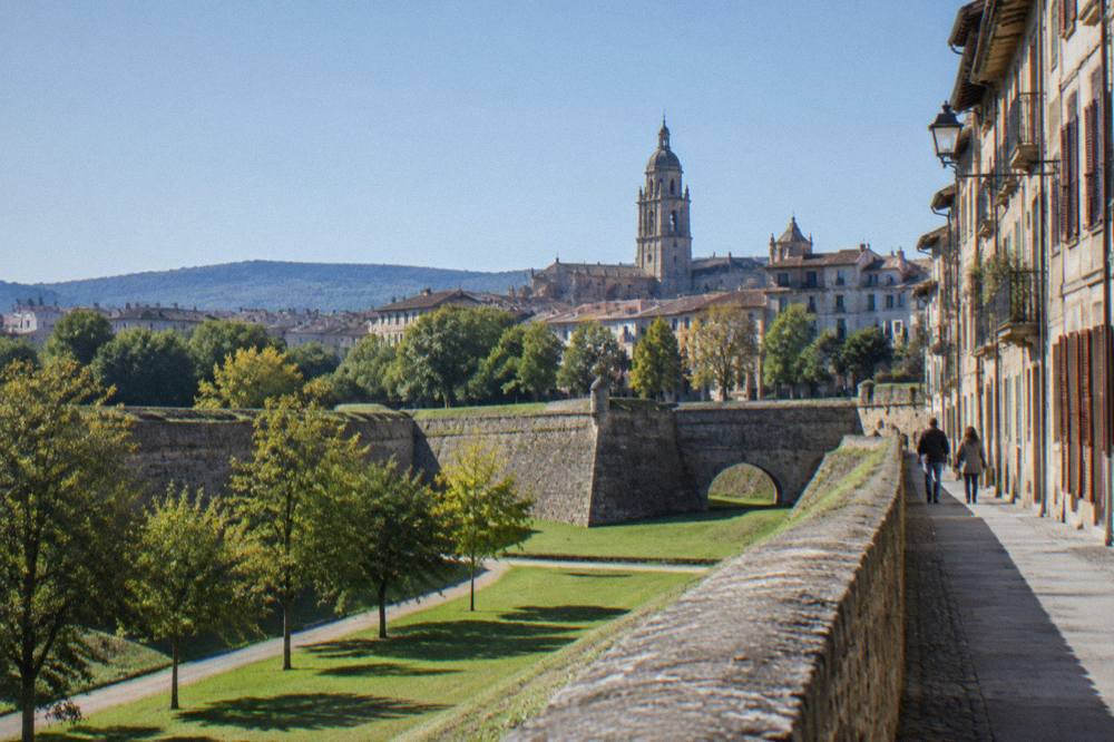 Stone ramparts and green lawns of Pamplona's city walls on a bright morning