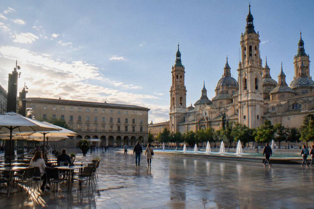 Arcaded square in Pamplona old town with café tables and pedestrians
